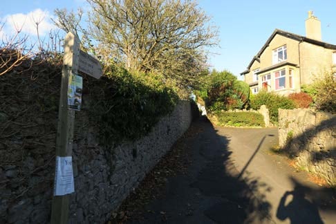 Signpost highlights path toward two houses at the end of the Arnside Knott Walk.